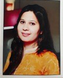 Portrait of Dr. Kapoor wearing traditional attire with academic books in background